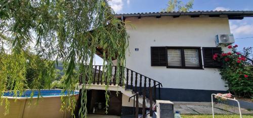 a house with a balcony next to a swimming pool at Vikendica Iris in Laktaši