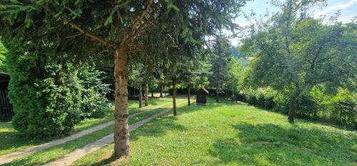 a row of trees in a park with a path at Vikendica Iris in Laktaši