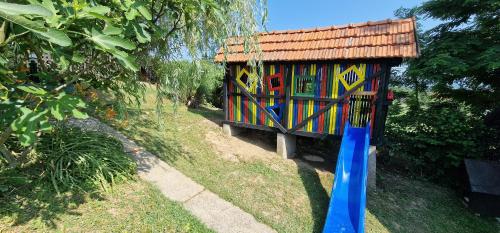 a small house with a blue shovel in the grass at Vikendica Iris in Laktaši