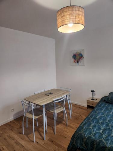 une pièce avec une table, des chaises et un lit dans l'établissement Appartement 103, à Avallon