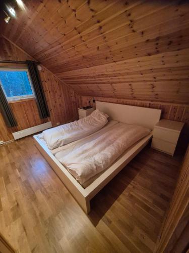 a bed in a room with a wooden ceiling at Roligheten hytte in Farsund