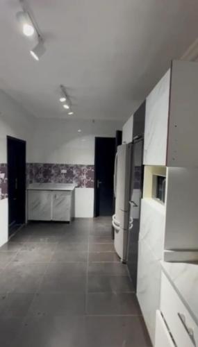 a large kitchen with refrigerators in a room at Adegbaju's Principal 4bedroom duplex standalone apartment in Araromi