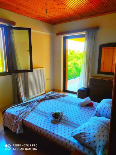a bedroom with a bed and a large window at The best view in Zakharo