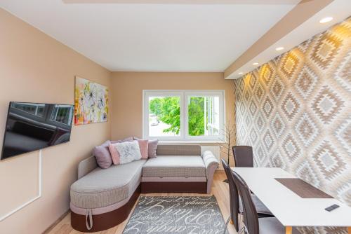 a small living room with a couch and a window at Vila Romantika in Palanga