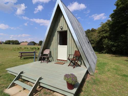 ein kleines Gewächshaus mit Stühlen und einer Veranda in der Unterkunft Robin in Woodbridge
