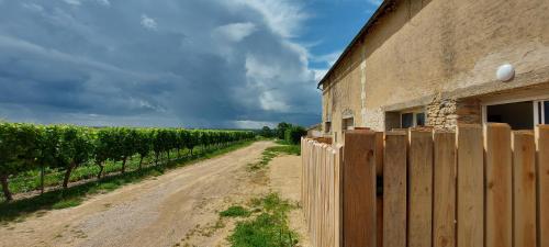 a dirt road next to a building and a fence at Gîte Le Saint Martin 1 - 4 pers. in Blaslay