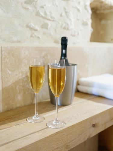 - deux verres de vin assis sur une table en bois dans l'établissement L’Oxalis villa, Sauna et Jaccuzi privatif, à Bullion