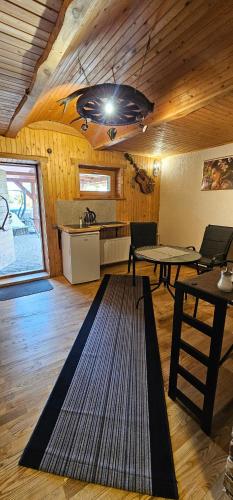 a living room with a table and a kitchen at Dīva in Pāvilosta