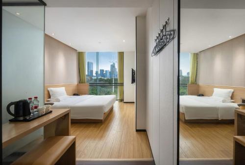 广州Locals Hotels Guangzhou Sports Center Linhe West Subway Station Branch的一间有两张床、可欣赏城市景观的酒店房间