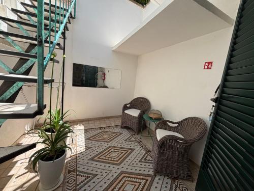 a room with two chairs and a table and stairs at B&b Ophelia in Otranto
