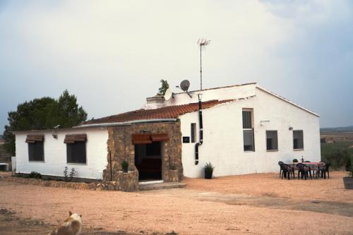 a white building with tables and chairs in front of it at Casa la Serrana in Yecla