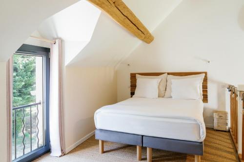 una camera da letto con un letto e una finestra di L’Oxalis villa, Sauna et Jaccuzi privatif a Bullion