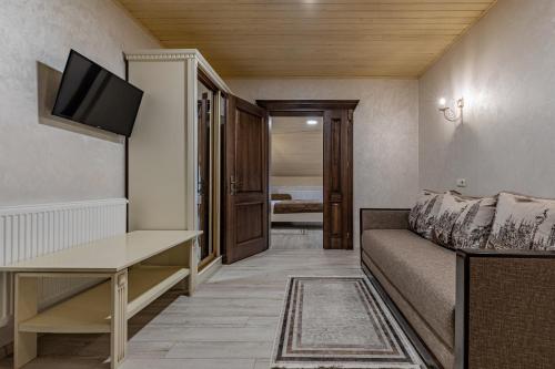 a small living room with a couch and a television at Premium hotel & SPA in Bukovel