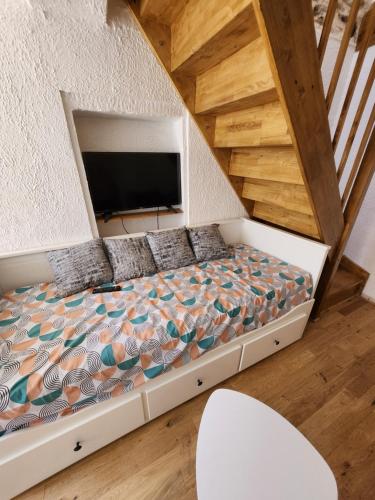 une chambre avec un lit avec une télévision dessus dans l'établissement Saint Père en Vézelay, à Saint-Père