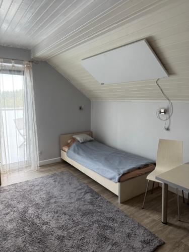 a bedroom with a bed and a desk and a window at Pokoje gościnne Anna in Rewa