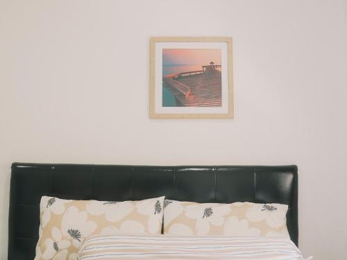 a bed with a black headboard and a picture on the wall at Boxsoon Nimman 2 # 4beds 3baths in Chiang Mai
