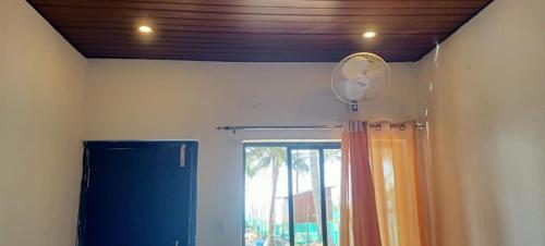 a room with a blue refrigerator and a window at Ayushyam beach stay in Gokarna
