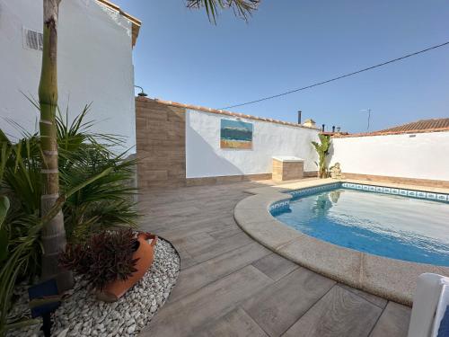 a backyard with a swimming pool and a house at El Levante in Chiclana de la Frontera