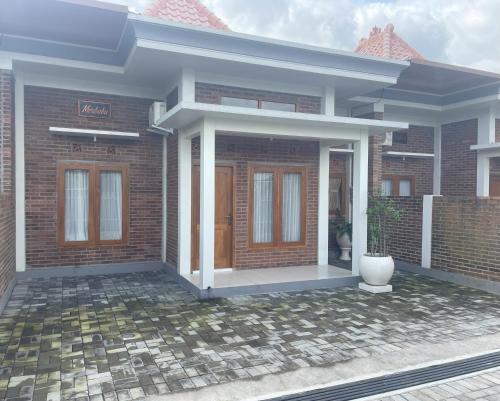 a rendering of a house with a front porch at Homestay Omah Embun in Godean