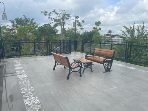 two benches and a table on a patio at Homestay Omah Embun in Godean