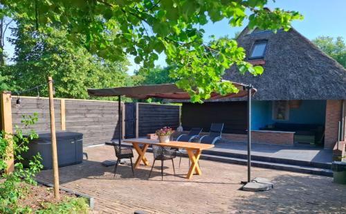 a patio with a table and chairs under an umbrella at De Reesterhoeve in Balkbrug