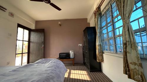 a bedroom with a bed and a large window at Tala Vista Stay in Pokhara