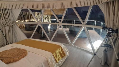 a room with a window with a bed and a camera at Dome Bally Kampia in Kambiá