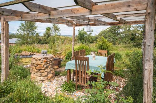 a table and chairs under a wooden pergola at Warriors View in Drumahayre