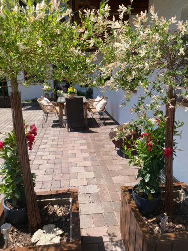 a patio with two potted trees and a table and chairs at Landhaus Trinker in Schladming