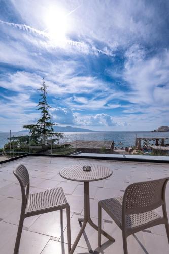 a patio with a table and chairs and the ocean at Grand Hotel Saranda in Sarandë