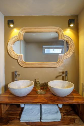 La salle de bains est pourvue de 2 lavabos sur un comptoir en bois avec un miroir. dans l'établissement Le duplex de la Villa Morane, à Perpignan