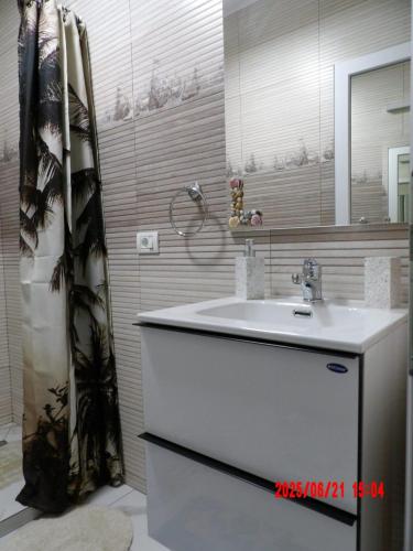 a bathroom with a sink and a mirror at Apartament DelyMar in Agigea