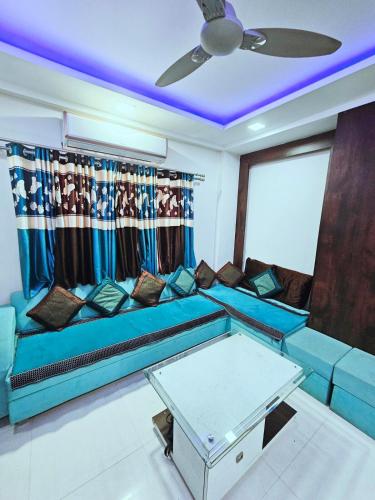 a blue couch in a living room with a ceiling at Beautiful Appartment in Indore