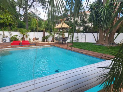 - une grande piscine dans un jardin avec une table et des chaises dans l'établissement Maison familiale avec piscine calme entre golf et mer, à La Grande Motte