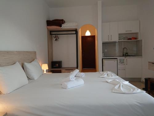 a bedroom with a white bed with towels on it at Postman's house in Parga