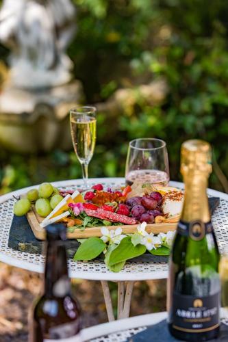 a table with a plate of food and two glasses of wine at Hôtel Le D'Avaugour in Dinan