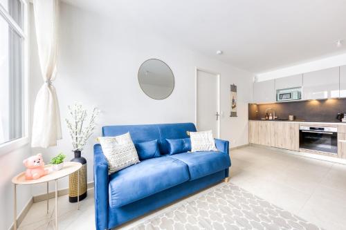 - un canapé bleu dans un salon avec une cuisine dans l'établissement Propriété Privée Neuve 2025 - Parking Privé Gratuit - 10mn Paris RER D - Lit 160X200 - Tout équipé - De 1 à 4 pers - Near Paris Brand New Apart with Secure Parking, à Maisons-Alfort