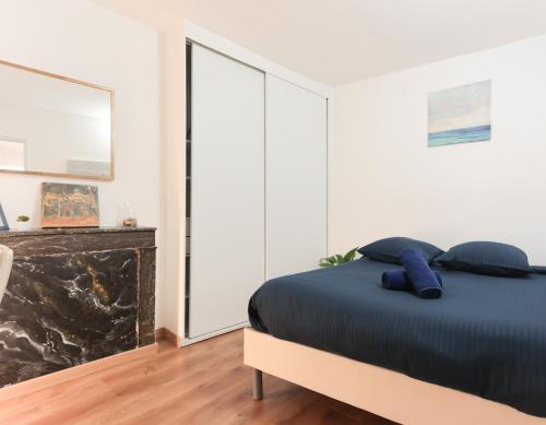 une chambre avec un lit avec des oreillers bleus dessus dans l'établissement Appartement très cosy quartier Notre-Dame, Panthéon, Saint-Germain-des-Prés, à Paris