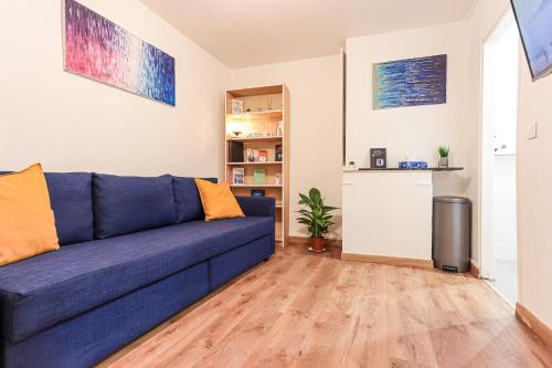 - un canapé bleu dans le salon doté de parquet dans l'établissement Appartement très cosy quartier Notre-Dame, Panthéon, Saint-Germain-des-Prés, à Paris