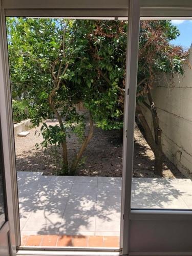 d'une porte en verre ouverte avec vue sur le jardin. dans l'établissement T2 climatisé à 10 min des plages, à Perpignan