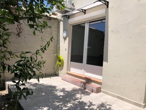 une porte d'entrée d'une maison avec une fenêtre dans l'établissement T2 climatisé à 10 min des plages, à Perpignan