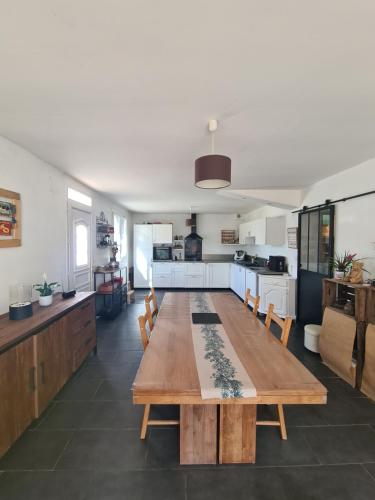 Il comprend un salon avec une table en bois et une cuisine. dans l'établissement Villa avec jardin in Provence, à Pernes-les-Fontaines
