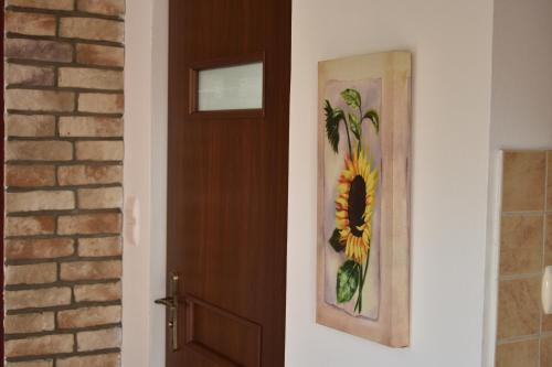 a door with a picture of a sunflower next to it at Przystanek Berdo in Zawóz