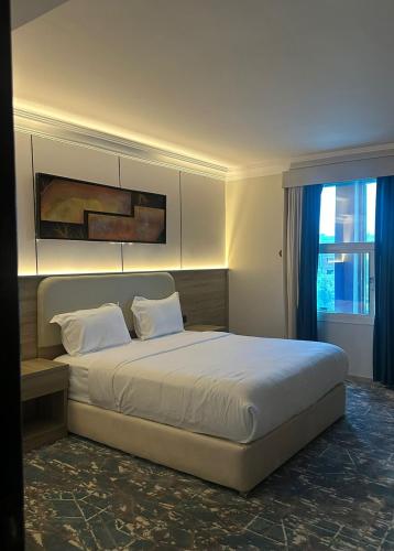 a bedroom with a large bed and a window at راحتي للشقق المخدومة in Taif