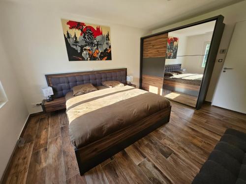 une chambre avec un grand lit et un grand miroir dans l'établissement Chez Florine - Maison Cosy, à Villemoustaussou
