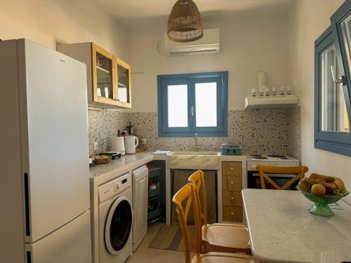 a kitchen with a white refrigerator and a table with chairs at Thalassea house2 Lipsi in Lipsoi