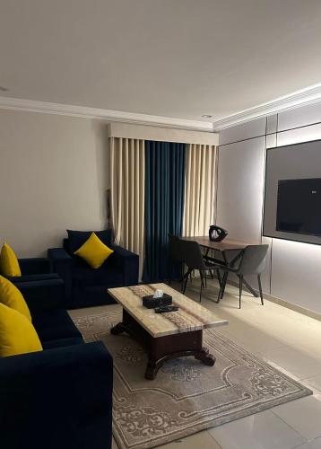 a living room with a blue couch and a table at راحتي للشقق المخدومة in Taif
