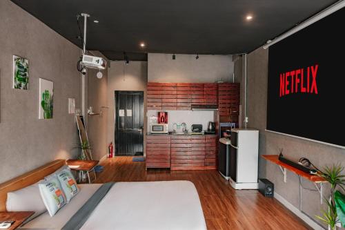 a room with a bed and a kitchen with a refrigerator at Saigon Hideout New World View in Ho Chi Minh City