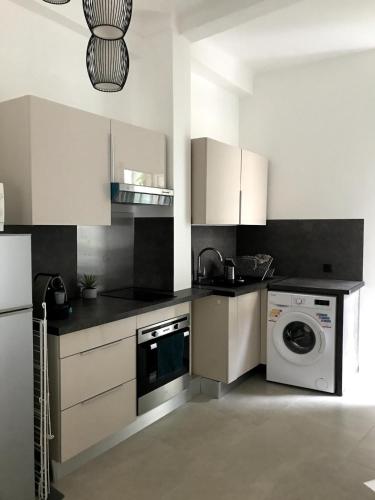 une cuisine avec un lave-linge et un lave-linge dans l'établissement charmant 2 pièces, à Nice