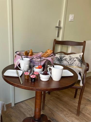 una mesa con tazones y platos de comida. en Maison Côté Halle La chambre de l'Artiste, en Saint-Flour